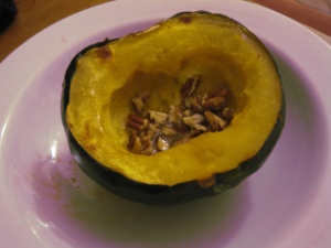 baked acorn squasy with butter, maple syrup and pecans